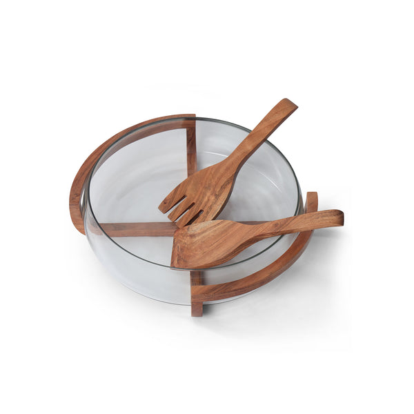 Wooden salad servers on a glass bowl with a white background