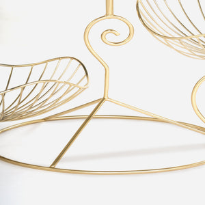 Gold wire wall art with leaf design on a white background