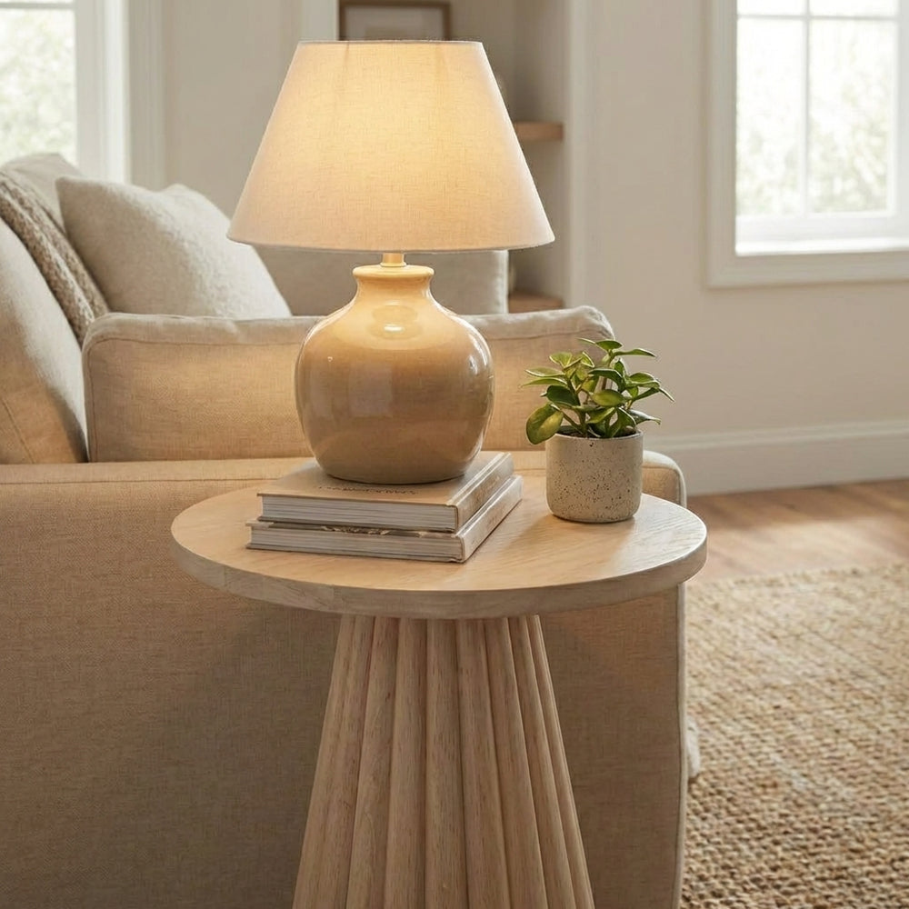 Cozy living room with a beige armchair, side table, and lamp.