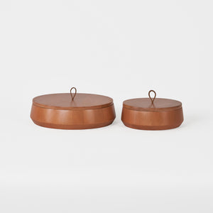 Two brown leather boxes with lids on a white background