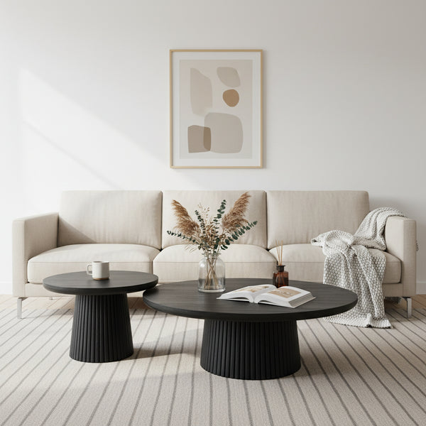 Modern living room with a beige sofa, black coffee table, and abstract art on the wall.
