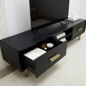 Black TV stand with gold legs and drawers, displaying a television and decorative items.